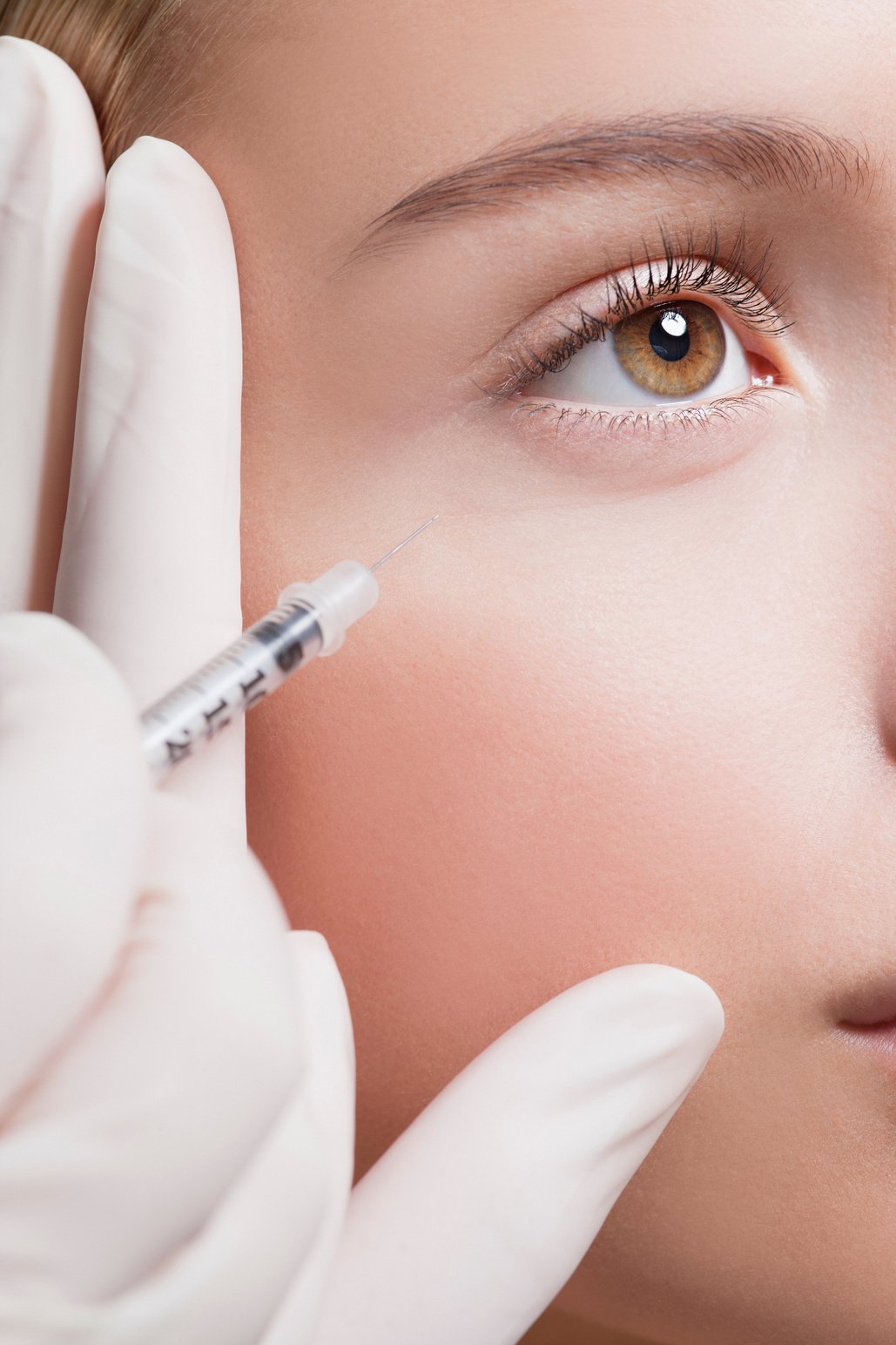 Close up of woman receiving botox injection under eye